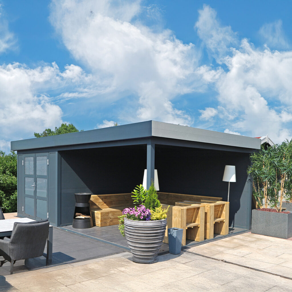 Moderne Gartenhütte mit Holzmöbeln, umgeben von Pflanzen, unter blauem Himmel mit Wolken.