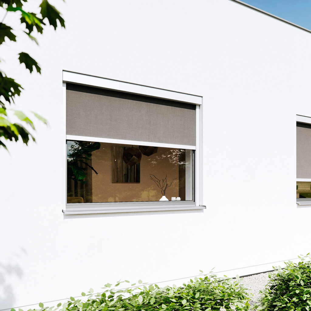 Ein modernes Gebäude mit weißen Wänden und zwei geschlossenen, grauen Jalousien.